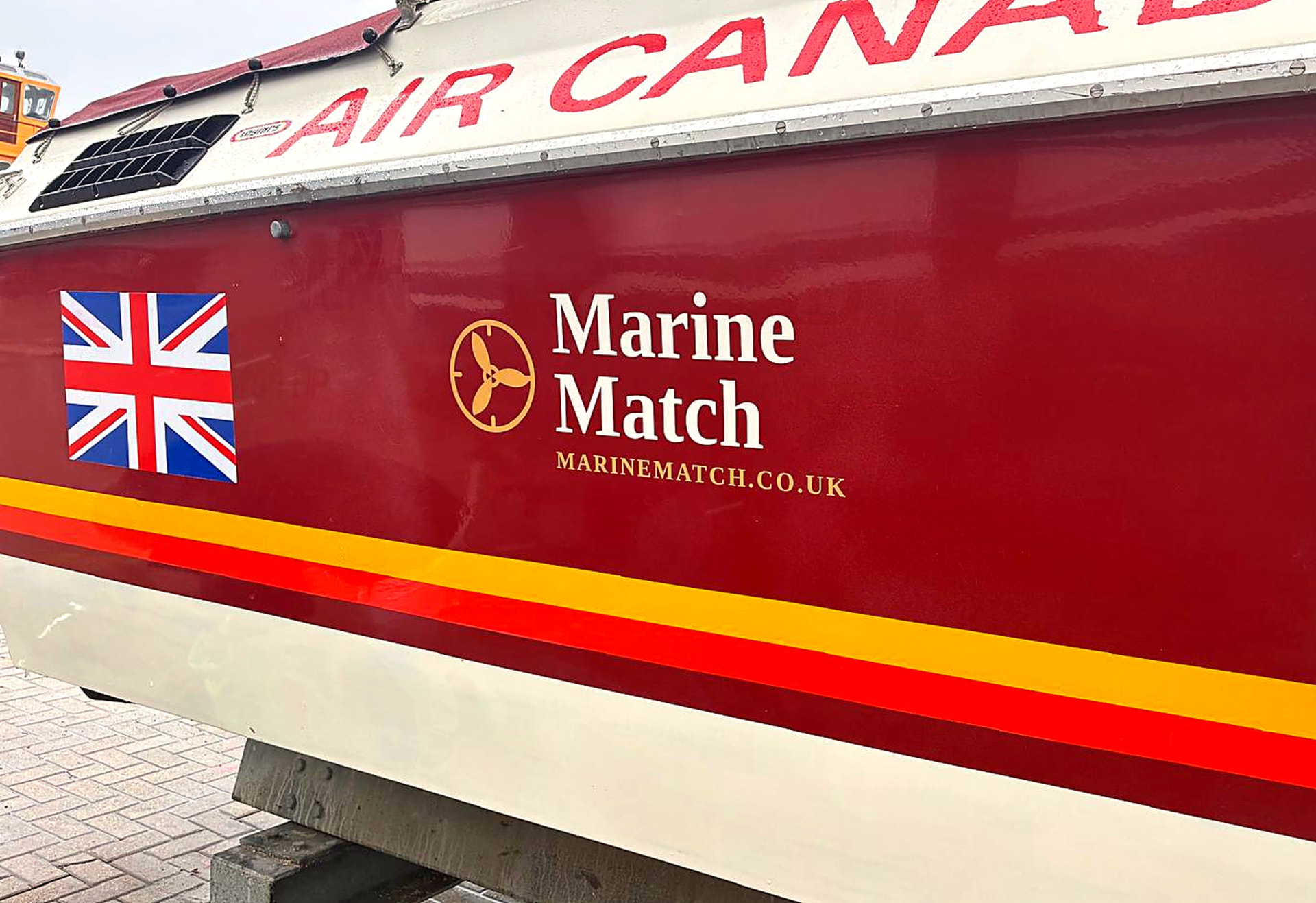 Marine Match propeller-and-compass logo and marinematch.co.uk decal on the red hull of the E-44 powerboat